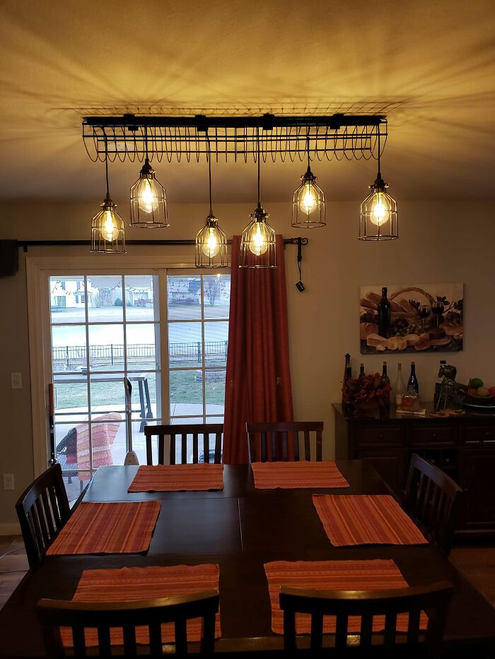 Dining room with unique caged light fixtures, showcasing creativity turning old junk into something worth keeping.