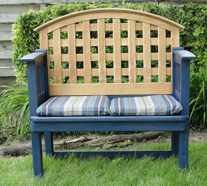 Blue outdoor bench with striped cushions, demonstrating creativity turning old junk into something worth keeping.