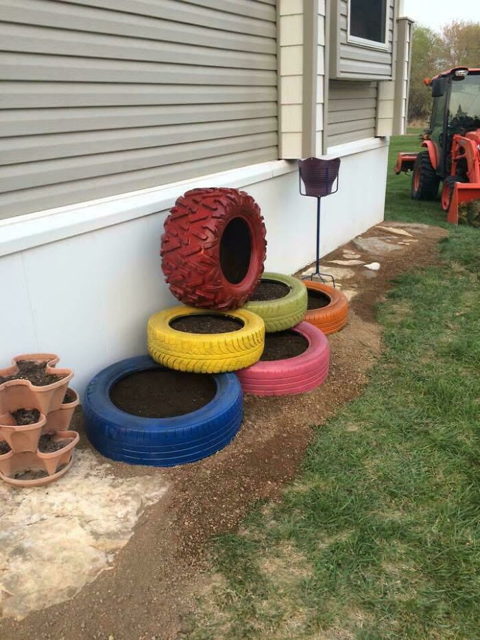 Colorful painted tires used as garden planters, showcasing creativity turning old junk into something worth keeping.