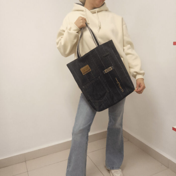 Person holding a tote bag made from old jeans, an example of creativity turning old junk into something worth keeping.