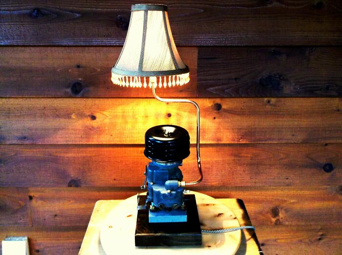 A unique table lamp crafted from an old engine part, showcasing creativity turning old junk into decor.