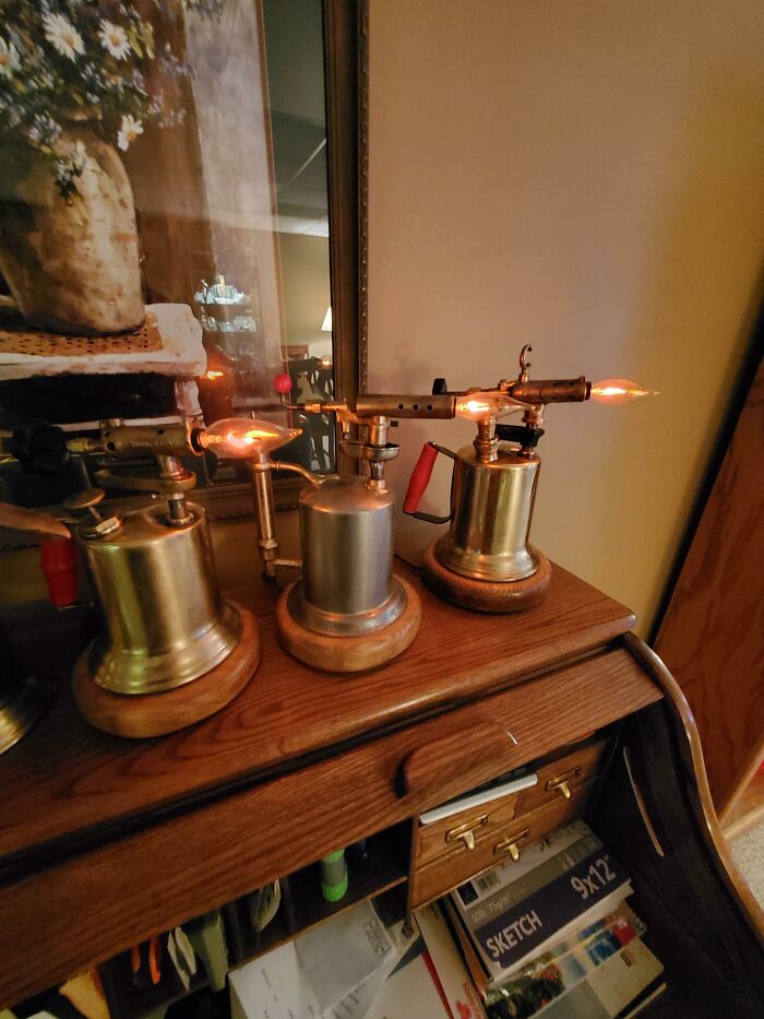 Three vintage-style lamps created from old blow torches, illustrating creativity turning old junk into lighting.