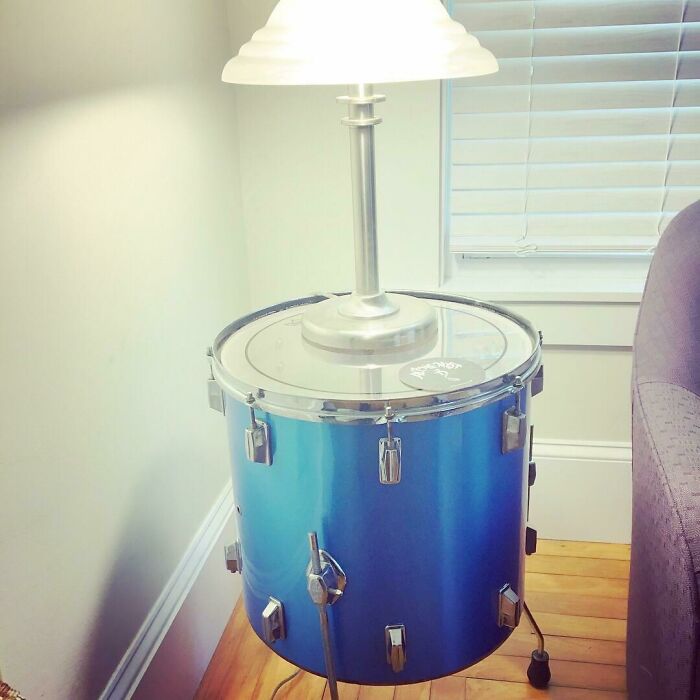 A blue old junk drum transformed into a stylish table lamp, an example of creativity in repurposing.