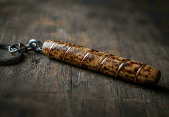 A handmade wooden keychain with copper accents, showing how creativity turns old junk into something new.