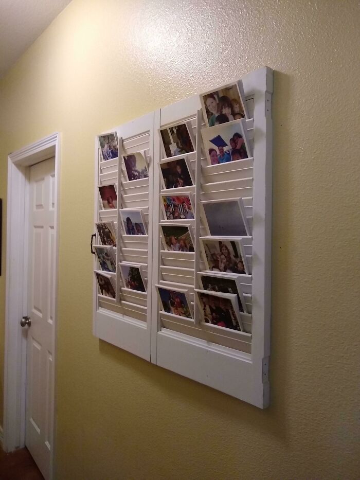 A wall-mounted display of photos on repurposed shutters, a creative way to keep memories.