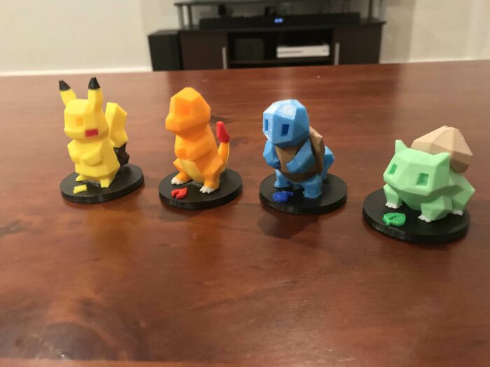 Amazing 3D printing creations: low-polygon figures of Pikachu, Charmander, Squirtle, and Bulbasaur on a table.