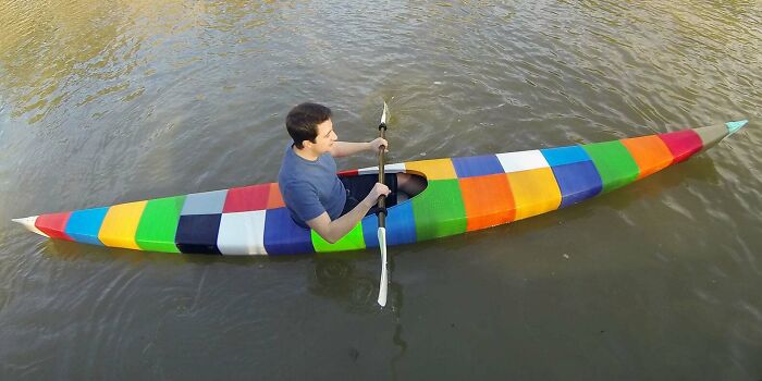 A person paddles a colorful, block-patterned 3D printing kayak on the water, highlighting amazing 3D printing creations.