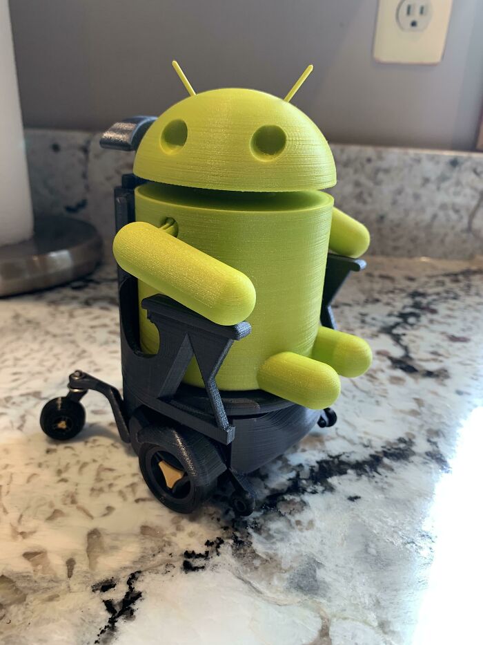 Green Android figure in a wheelchair, a unique 3D printing creation.