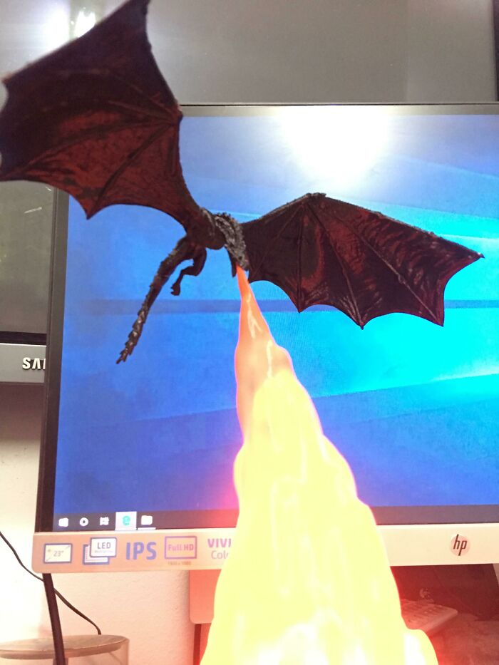3D printing dragon figurine appearing to breathe fire from a light, an amazing 3D printing creation.