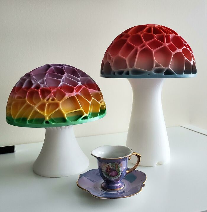 Two amazing 3D printing mushroom lamps with vibrant colors and a small teacup, showcasing creative creations.
