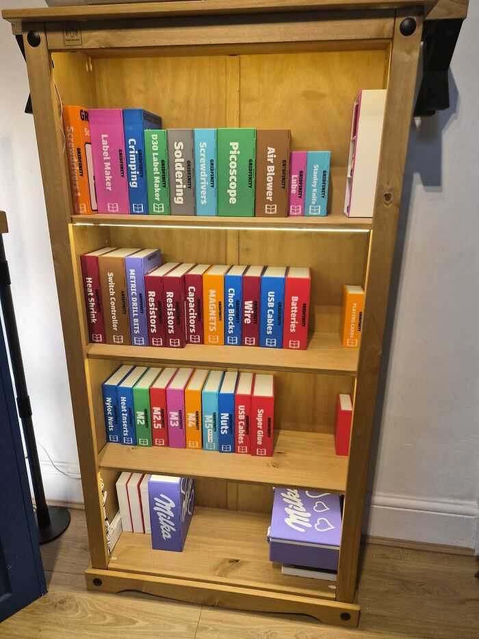 A wooden shelf filled with organized boxes of 3D printing tools and components, showing amazing creations.