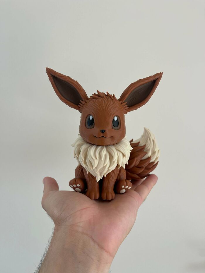 A hand holding a perfectly crafted 3D printing Eevee figure, an example of amazing creations.
