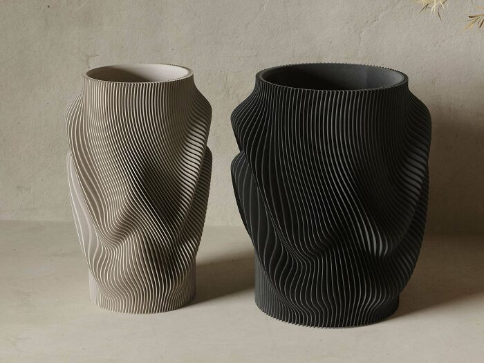 Two textured 3D printing vases, one light and one dark, displaying amazing creations with artistic flair.
