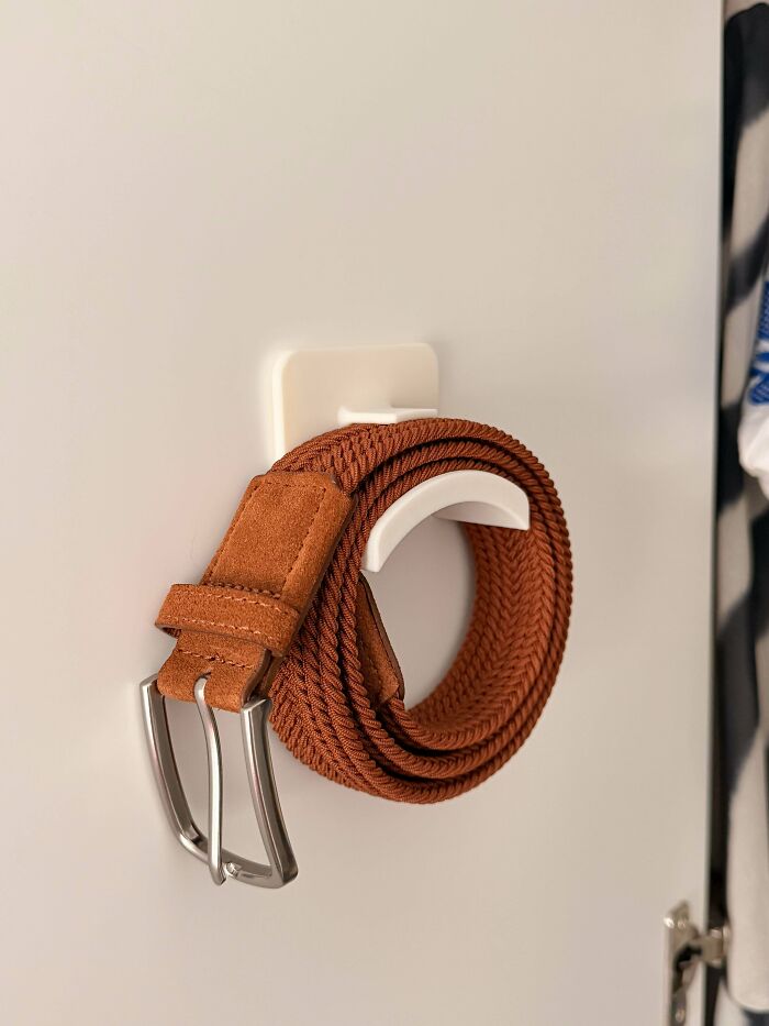 A brown braided belt hanging on a white 3D printing hook, demonstrating practical amazing creations.