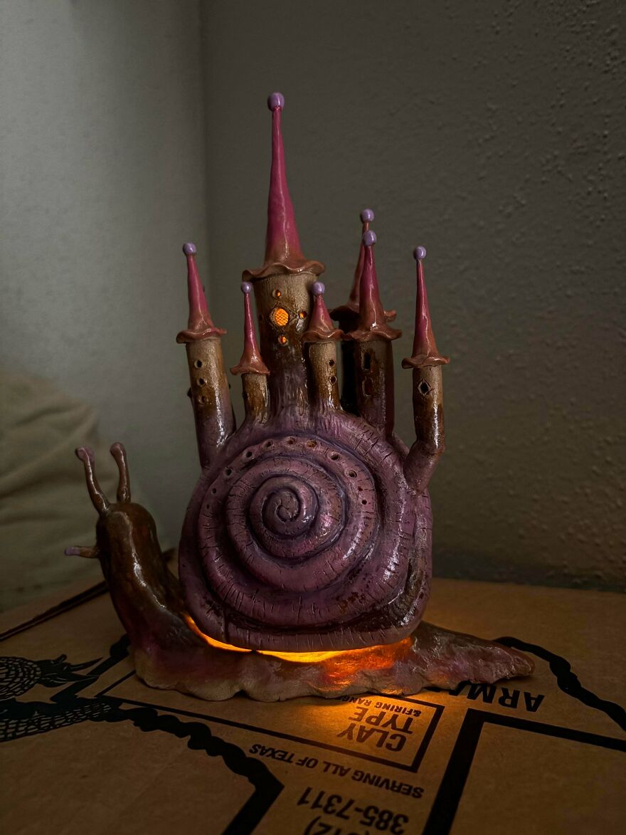 A snail shell transformed into a magical, whimsical castle craft, illuminated from within, creating a glowing effect.
