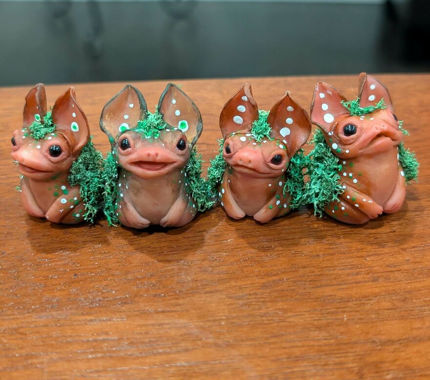 Four whimsical crafts of fantasy creatures resembling frogs with large ears, green moss, and white spots.