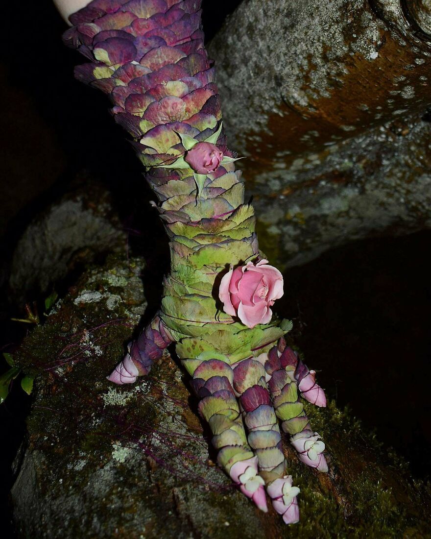 A hand covered in scales made of leaves and small pink roses, a magical whimsical craft shared online.