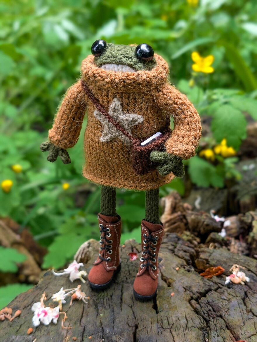 Whimsical crafts: A crocheted frog wearing a sweater and boots, standing on a log, a truly magical and cute item.