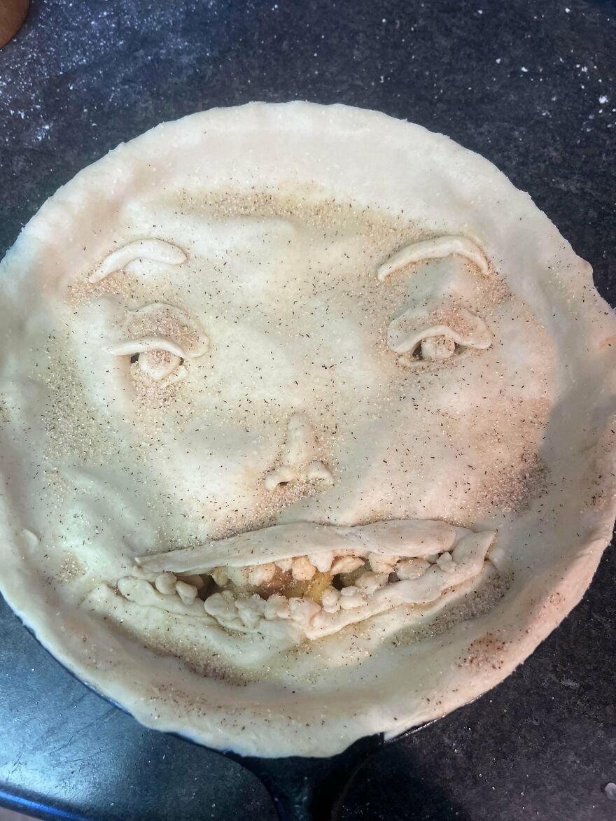 A whimsical craft of a pie crust decorated with a face, sprinkled with spices, creating a magical design.