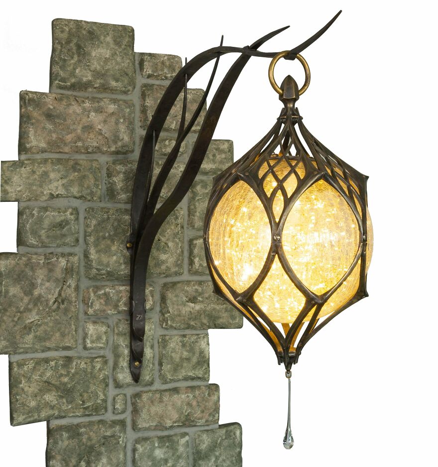 An ornate, illuminated lantern affixed to a stone wall, showcasing magical whimsical crafts.