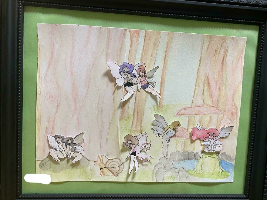 A framed whimsical crafts artwork featuring paper cut-out fairies in a painted forest background with trees and mushrooms.