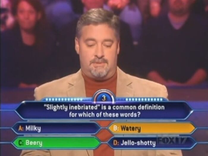 A man contemplating dumb Who Wants To Be A Millionaire answers, unsure of the correct definition for slightly inebriated.