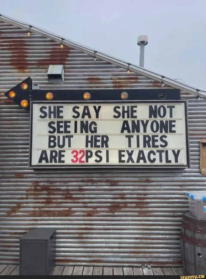 A funny meme on a sign: 'She say she not seeing anyone but her tires are 32 PSI exactly,' hinting at a partner.