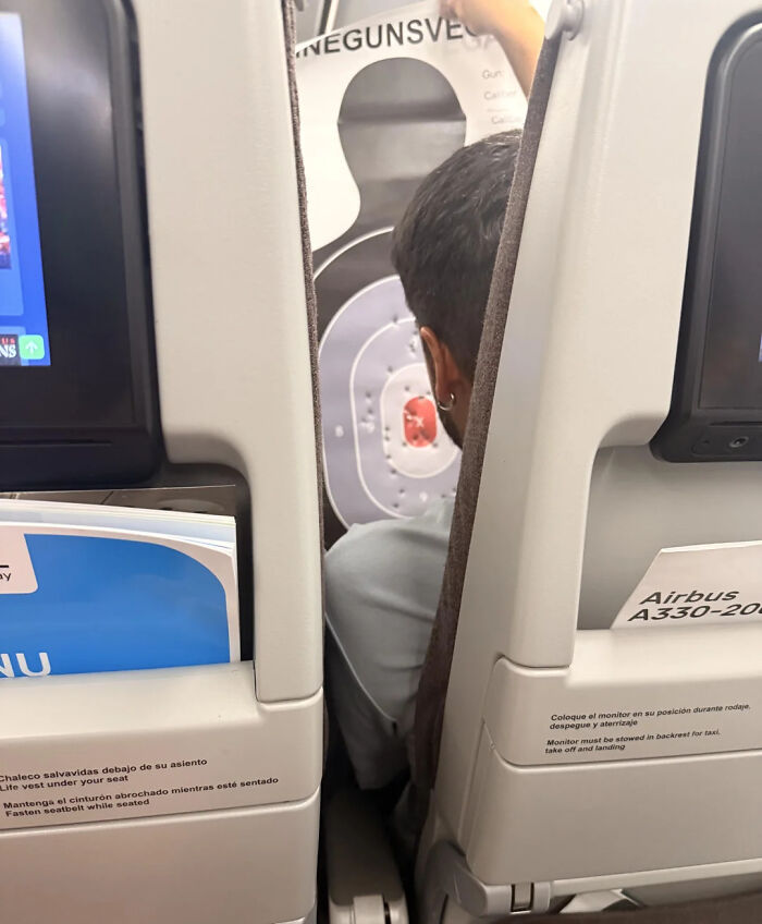 A passenger on an airplane with a target silhouette between seats. Funny memes for health.