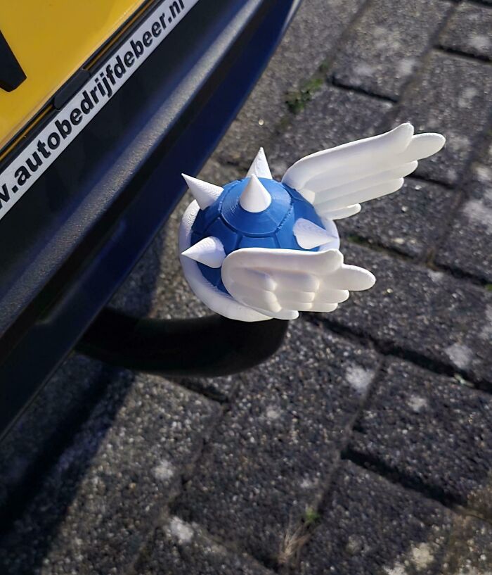 A blue spiked shell with white wings, a cool 3D printed Mario Kart item attached to a car, a fun project.