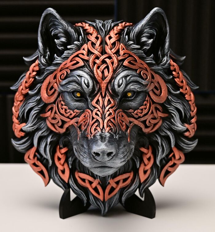An impressive 3D printer project of a wolf's head with intricate Celtic knot patterns in metallic orange and silver.