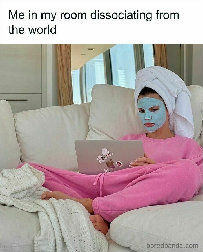 A woman with a face mask, towel on her head, and pink pajamas on a couch with a laptop, reflecting funny posts about being a woman.