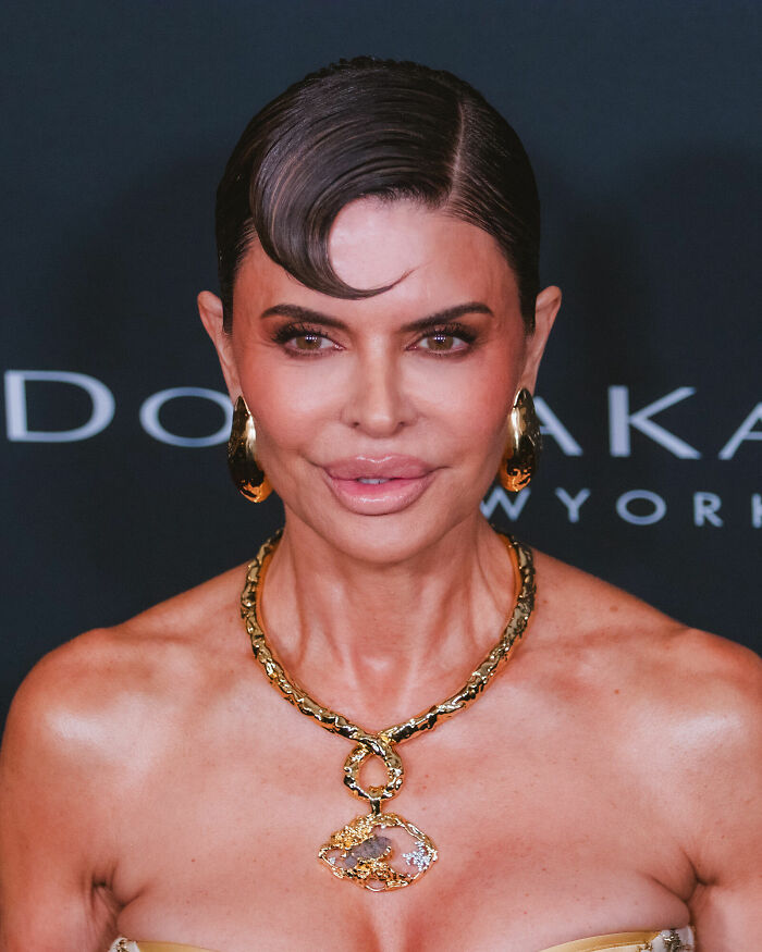 Lisa Rinna showing her career highlights, wearing a golden necklace and earrings.