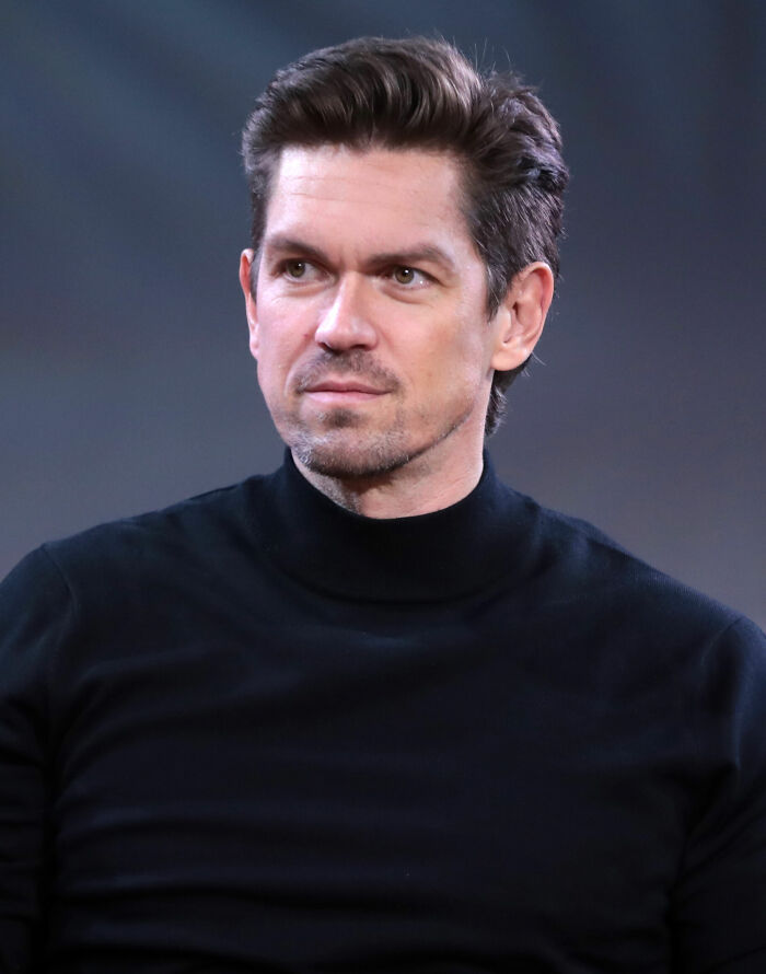 Steve Howey in a black turtleneck, looking to the side, highlighting his career