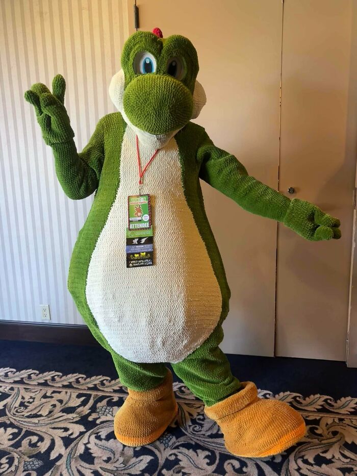 Full-body crochet costume of green character with large yellow shoes