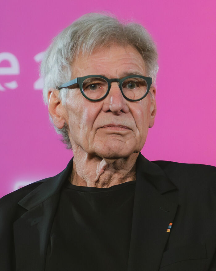 A close-up of Harrison Ford, a prominent actor, wearing glasses and a black shirt, showcasing his iconic career.