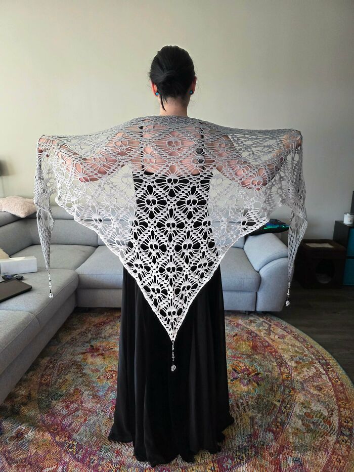 A woman wearing a beautiful white crochet shawl with intricate DIY creations, showcasing useful crochet creations.