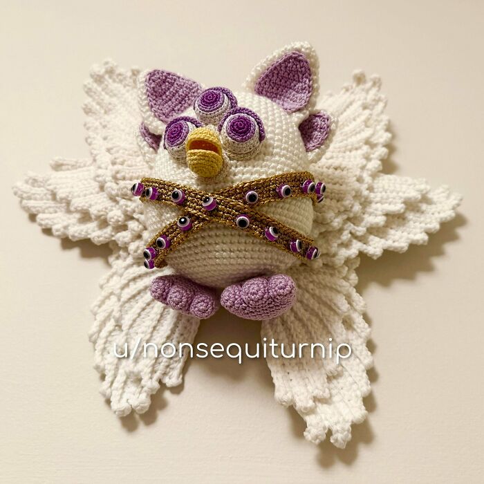A white and purple DIY crochet Furby with multiple eyes, a useful and unique creation.