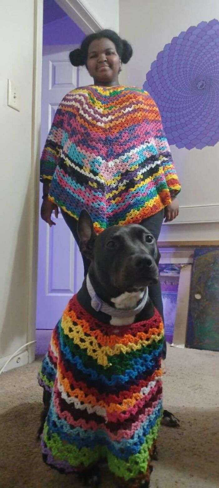 A girl and her pit bull dog both wearing matching colorful crochet ponchos, showcasing useful DIY crochet creations.