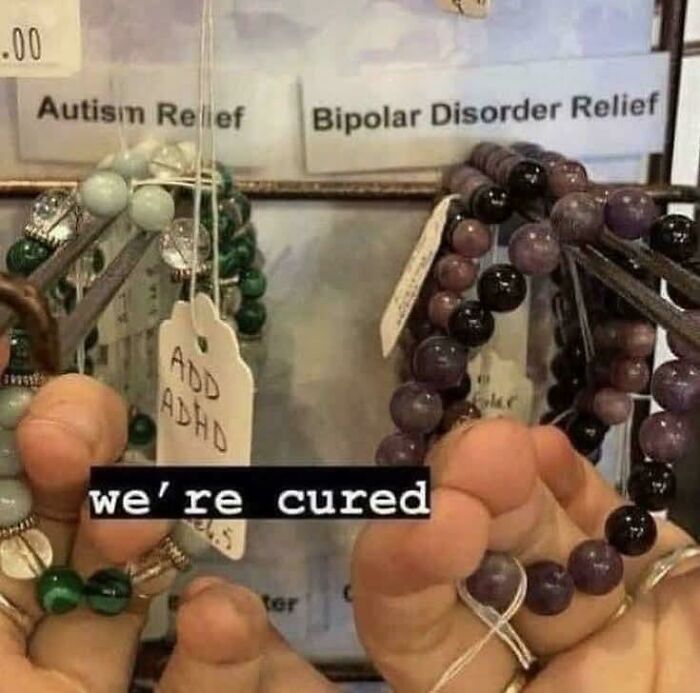 Two hands holding beaded bracelets labeled for Autism Relief and Bipolar Disorder Relief, with the text we're cured.