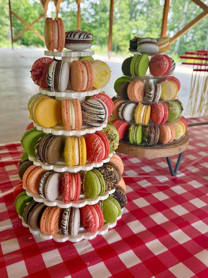 Two amazing baker's towers of colorful macarons, showcasing delicious treats on a red and white checkered tablecloth.