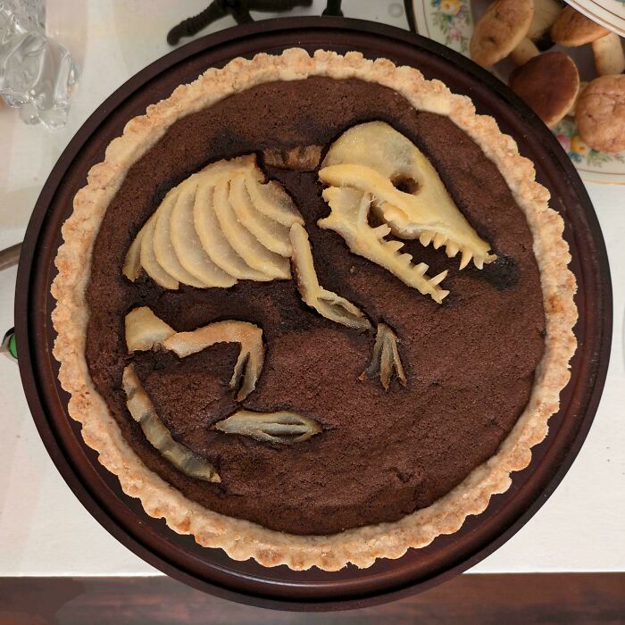 An amazing baker's dessert, a chocolate tart, decorated with a pear skeleton for a unique, delicious treat.