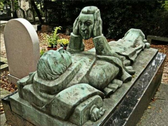A spooky grave statue depicting a person with their head in their hands, creating a creepy image and nightmare fuel.