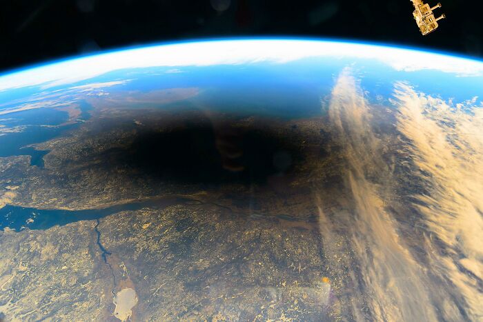 A wide shot of Earth from space showing a large, dark shadow, a creepy image that is nightmare fuel.