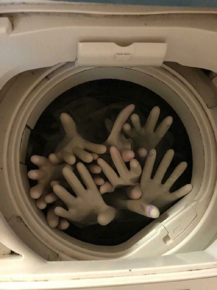 A washing machine full of creepy images of rubber gloves resembling dismembered hands, nightmare fuel for viewers.