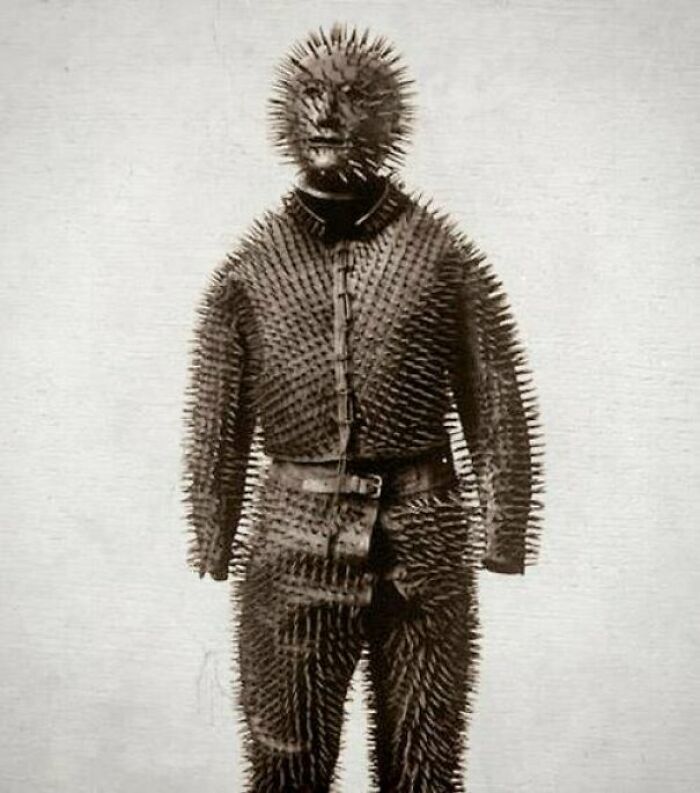 A full-body view of a person wearing a suit made entirely of sharp spikes, a truly creepy image.