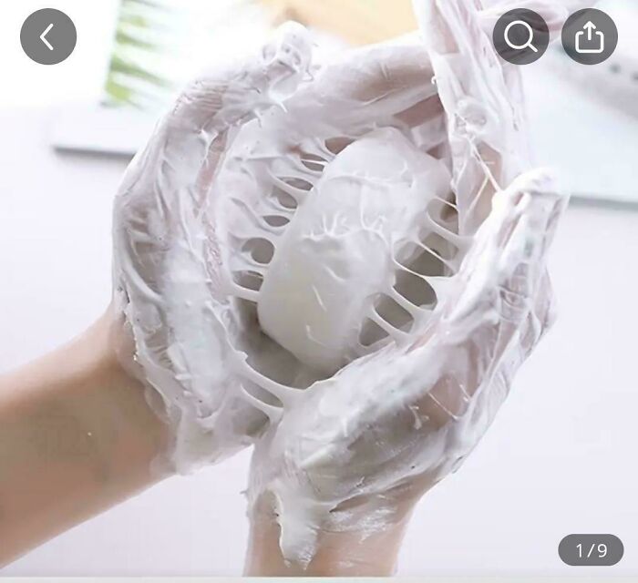 A pair of hands in white gloves covered in a sticky, web-like substance holding a white object, a creepy image for nightmare fuel.