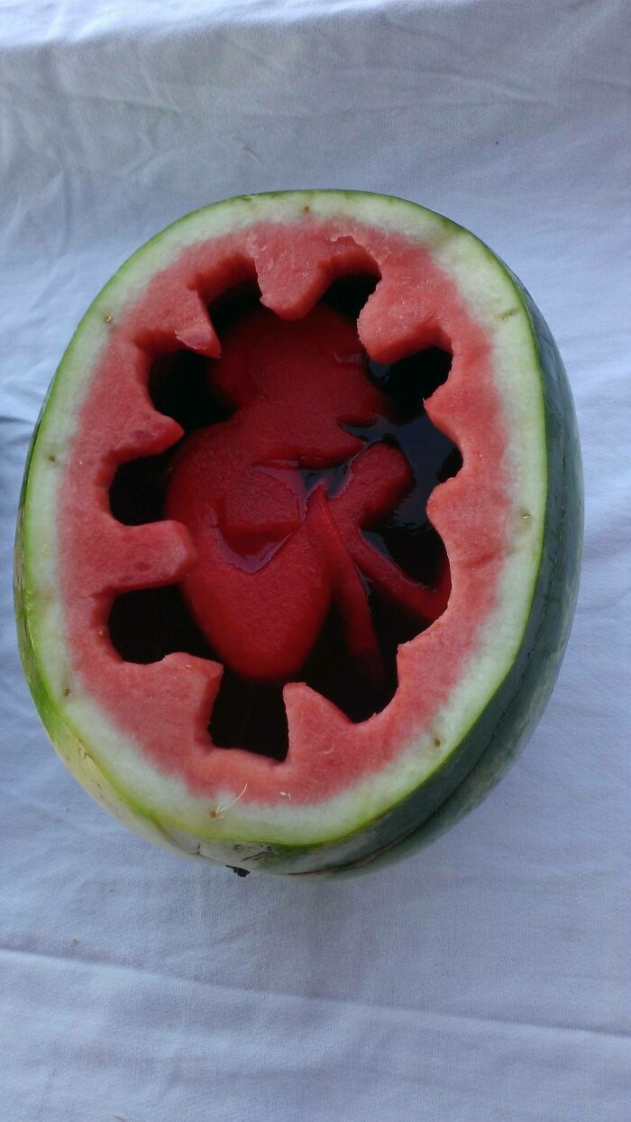 A watermelon carved to look like a baby in a womb, a piece of disgusting food.