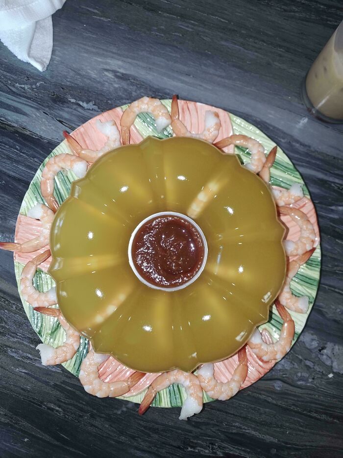 A gelatin mold with shrimp and cocktail sauce, appearing as disgusting food that deserves to be shamed.