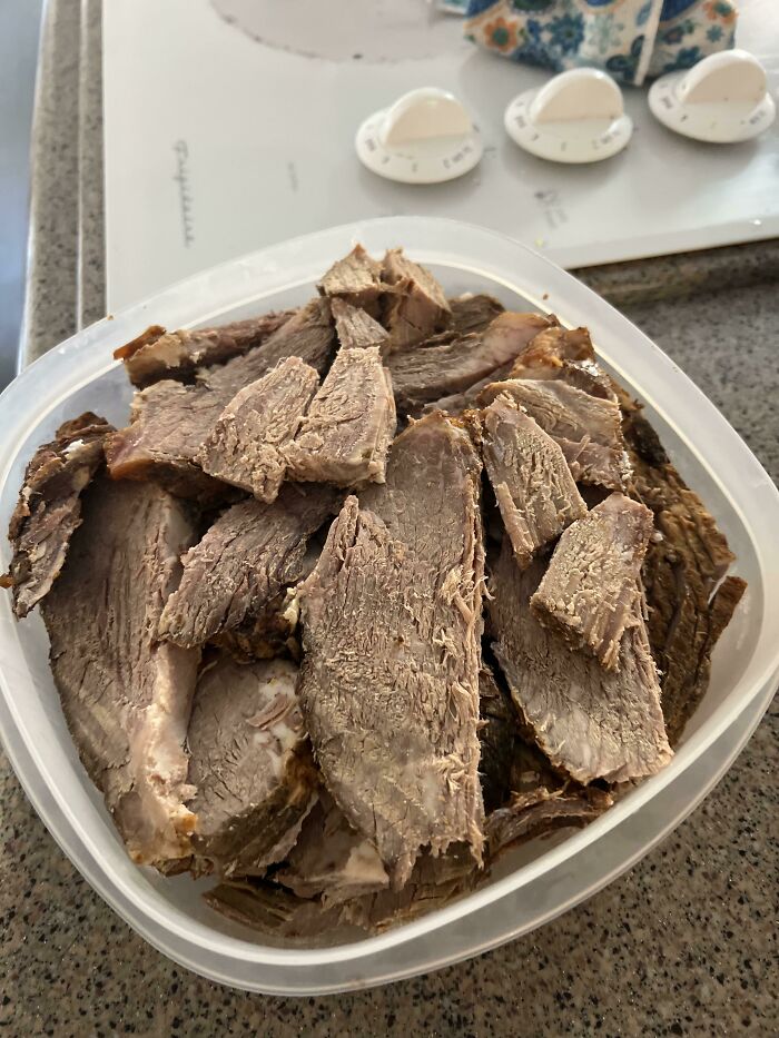 A container of dull, sliced meat with a dry texture, appearing unappetizing and truly disgusting food.