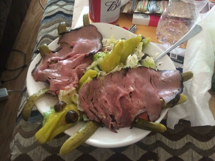 A plate of disgusting food: sliced roast beef, salad, and pickles arranged to resemble a turtle.